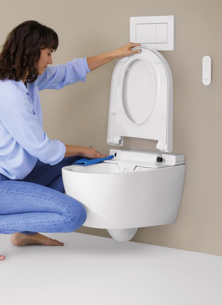 Woman cleans a toilet Woman cleans a toilet