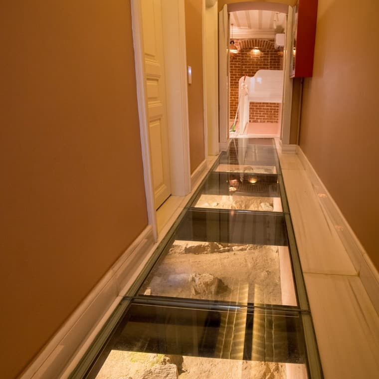 На первом этаже под стеклянными плитами пола видны древние остатки бывшей дворцовой садовой стены (© Hande Erçin) На первом этаже под стеклянными плитами пола видны древние остатки бывшей дворцовой садовой стены (© Hande Erçin)